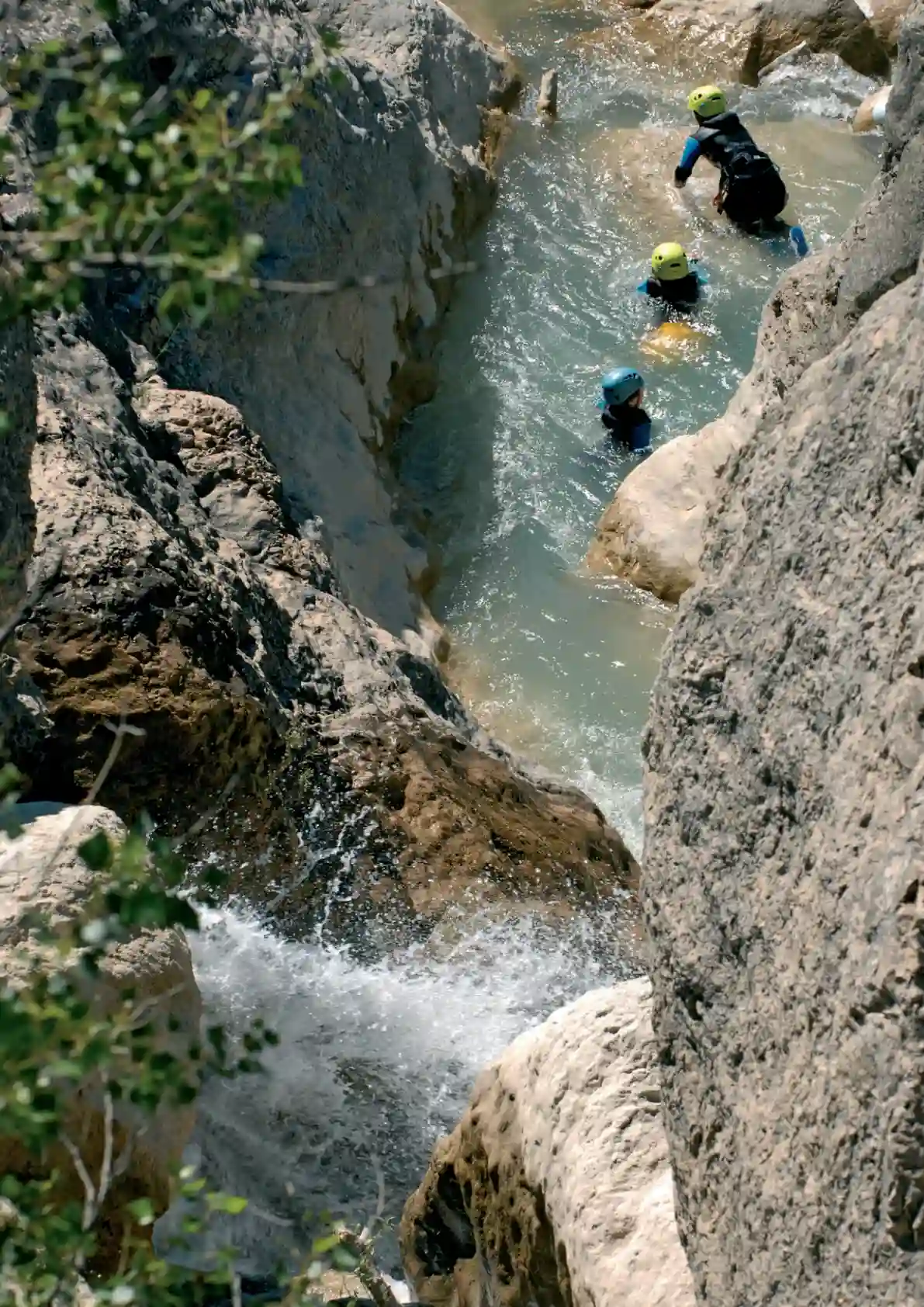 Enfant en canyoning dans la Drôme encadré par un guide dans une vasque naturelle