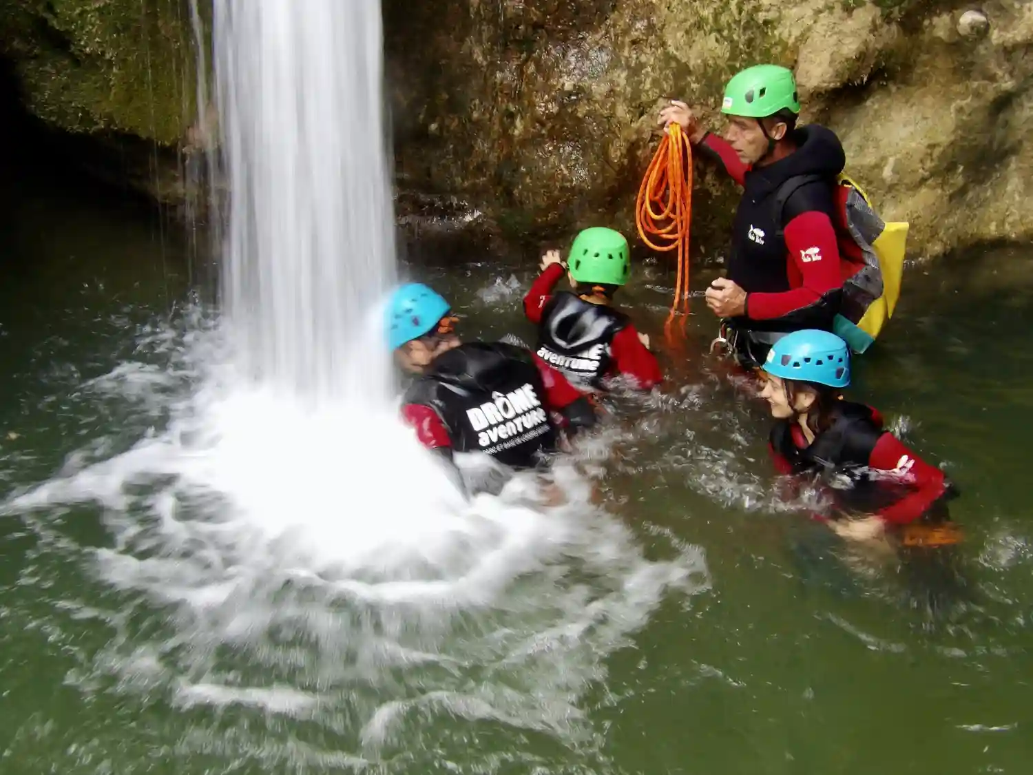 Famille en descente de canyon dans la Drôme entre parois calcaires et chute d'eau